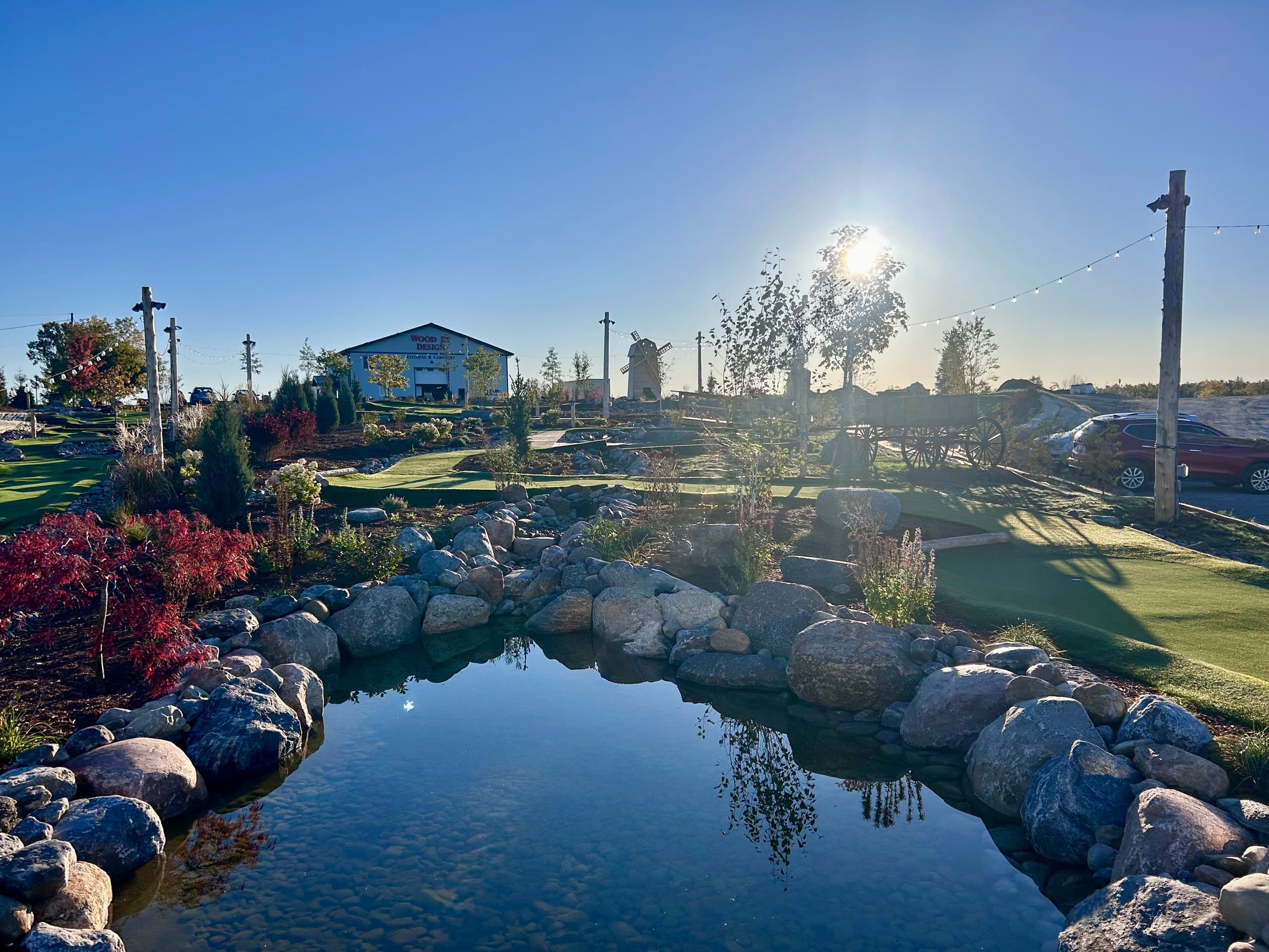 The pond and rock garden at sunset, with the windmill and barn behind